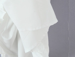 Détail du tissu blanc pur de la robe en dentelle avec tissage plat et coutures de qualité