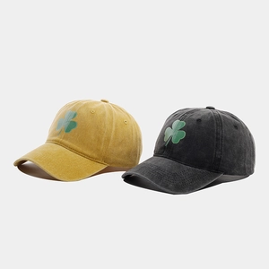 Dettaglio di cappellini vintage in cotone lavato zenzero e antracite con logo trifoglio