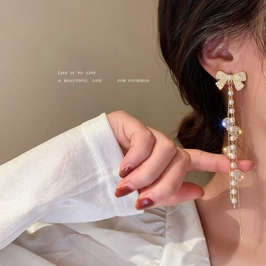 Boucles d'oreilles nœud dorées avec perles et glands en cristal au style chic