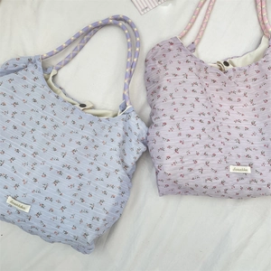 Dettaglio di borse tote in tela a fiori con stampe ciliegia e manici in corda