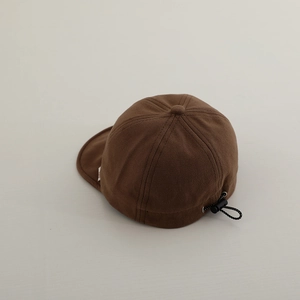 Detail of adjustable elastic drawstring and buckle on brown baby baseball cap