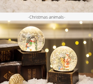 Detail view of snowman and Santa Claus glowing snow globes on a festive wood base