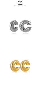 Close-up of gold and silver stainless steel ear cuffs with hammered and polished textures