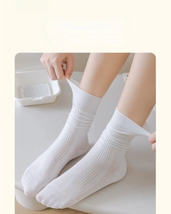 Nahaufnahme weißer gestreifter Baumwollsocken mit hoher Elastizität am Bein des Modells