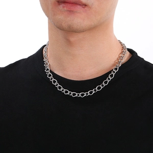 Detail of silver stainless steel curb chain with lobster clasp worn by a model
