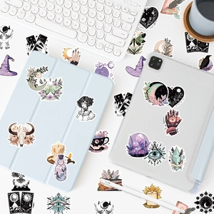 Detail of mystical witch stickers featuring tarot and crystals on a blue tablet case