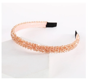 Macro detail of multi-layer sparkling crystal beads on an elegant pink fabric headband