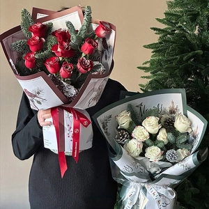Christmas bouquet with red roses and pine cones in festive Santa deer wrapping paper