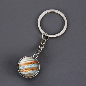 Detailed macro view of Jupiter planet glass cabochon pendant on silver metal keychain