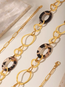 Detail of 18K gold plated necklace with leopard print oval resin link and mixed chain texture