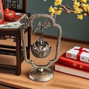 Vintage bronze lotus hanging incense burner with bird stand on a wooden table