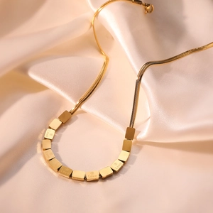 Golden snake chain necklace with square Love engraved pendants on pink silk
