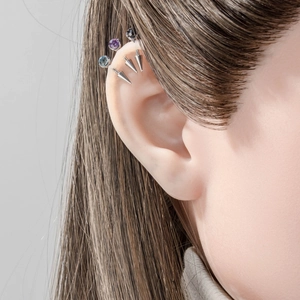 Titanium alloy earring set with purple and blue gemstones and metallic cone spikes on ear