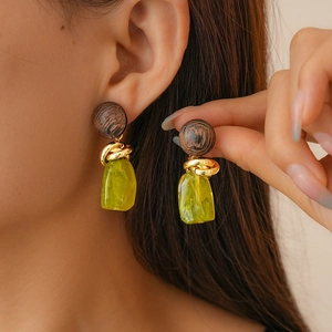 Close-up of retro irregular resin earrings with deep brown and yellow-green accents