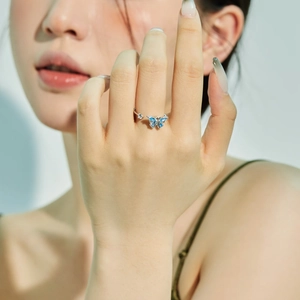 Close-up of elegant S925 silver butterfly ring with blue zircon worn by a model