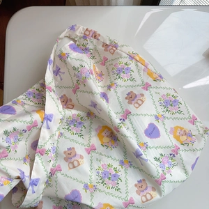 Detail of white cotton tote bag with colorful bear, floral and bow patterns