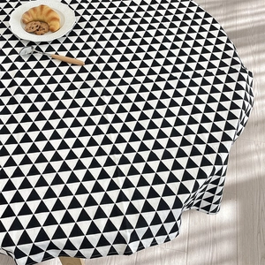 Detail of round cotton linen tablecloth with black and white triangle geometric patterns