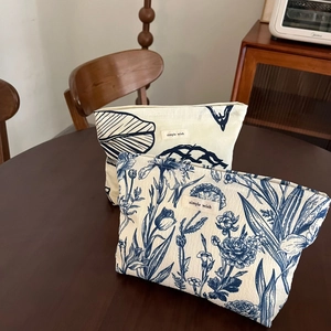 Floral cotton makeup bags with simple wish label on a dark wood table background