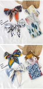 Detailed view of pleated silk scarves featuring polka dots and geometric patterns