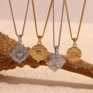 Macro view of 18K gold plated stainless steel tarot pendants with intricate embossing
