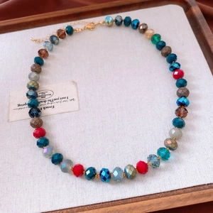 Detail of colorful faceted crystal beads necklace with adjustable lobster clasp on wood