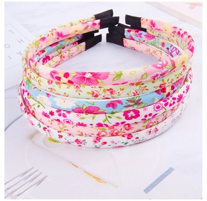 Close-up of stacked floral fabric headbands in pink blue and yellow summer patterns