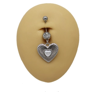 Detail of heart-shaped belly button ring with white zircon on silicone naval model