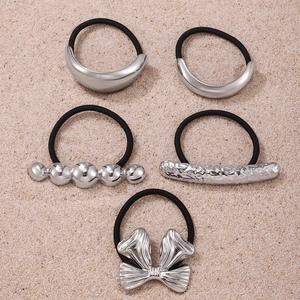 Set of five black elastic hair ties featuring diverse silver-tone metal charms and bows