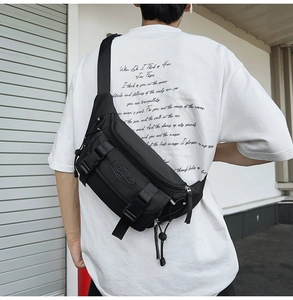 Black casual crossbody chest bag with adjustable strap shown on a male model back view