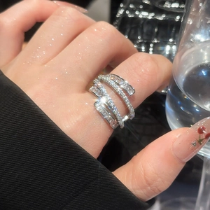 Close-up of four-layer silver spiral ring with shimmering zircon on finger