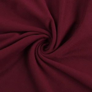 Détail du tissu en maille bordeaux montrant une texture fine et un effet drapé souple