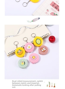 Close-up of cute cartoon retractable measuring tape keychain with dual-sided scale markings