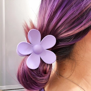 Matte purple flower hair claw clip worn by a girl with purple tinted hair accents