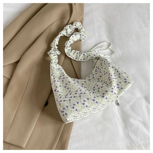 Close-up of floral drawstring bag with pleated shoulder strap and purple flower patterns
