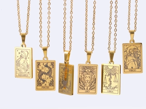 Detailed close-up of six gold stainless steel necklaces with zodiac name pendant engraving