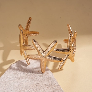 Macro detail of golden starfish bangle showing realistic texture on mineral stone