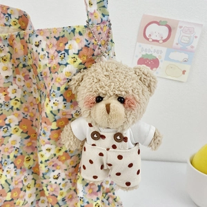 Portachiavi orsetto di peluche con salopette in velluto appeso a una borsa a fiori