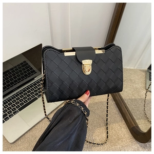 Detailed view of woven texture on black crossbody bag with gold chain strap