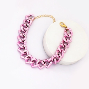 Detail showing the pink heart chain link pet necklace with a gold lobster clasp closure