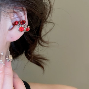 Close-up of sparkling burgundy zircon ear bone clips on a model's ear without piercings