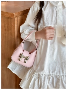 Close-up of pink PU leather handbag featuring a stylish silver metal bow detail