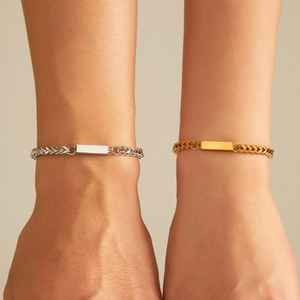 Close-up of minimalist gold and silver ID bracelets with polished rectangular bars