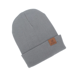 Close-up of a minimalist grey knitted beanie featuring a brown M logo leather patch