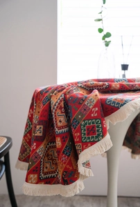 Detailed view of woven red table runner with geometric Persian pattern and fringed edges