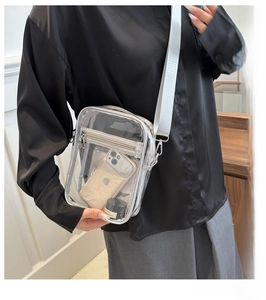 Close-up of transparent PVC crossbody bag showing internal capacity and fabric strap