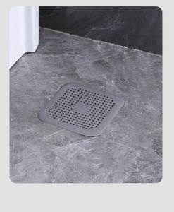 Dettaglio macro del coperchio per scarico quadrato in silicone grigio su pavimento in marmo