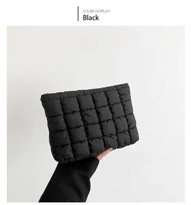 Detail of black quilted puffer bag showing square pattern and soft cotton texture