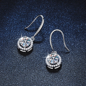 Classic round moissanite silver drop hook earrings with halo setting on a blue background