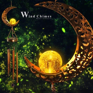 Solar moon wind chime with glowing yellow crackle glass ball in a dark magic forest