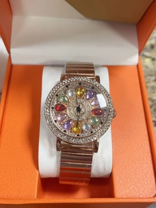 Detail of rose gold watch dial with colored crystals and rhinestones in an orange gift box